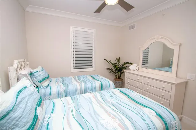 a bedroom with two beds and a potted plant