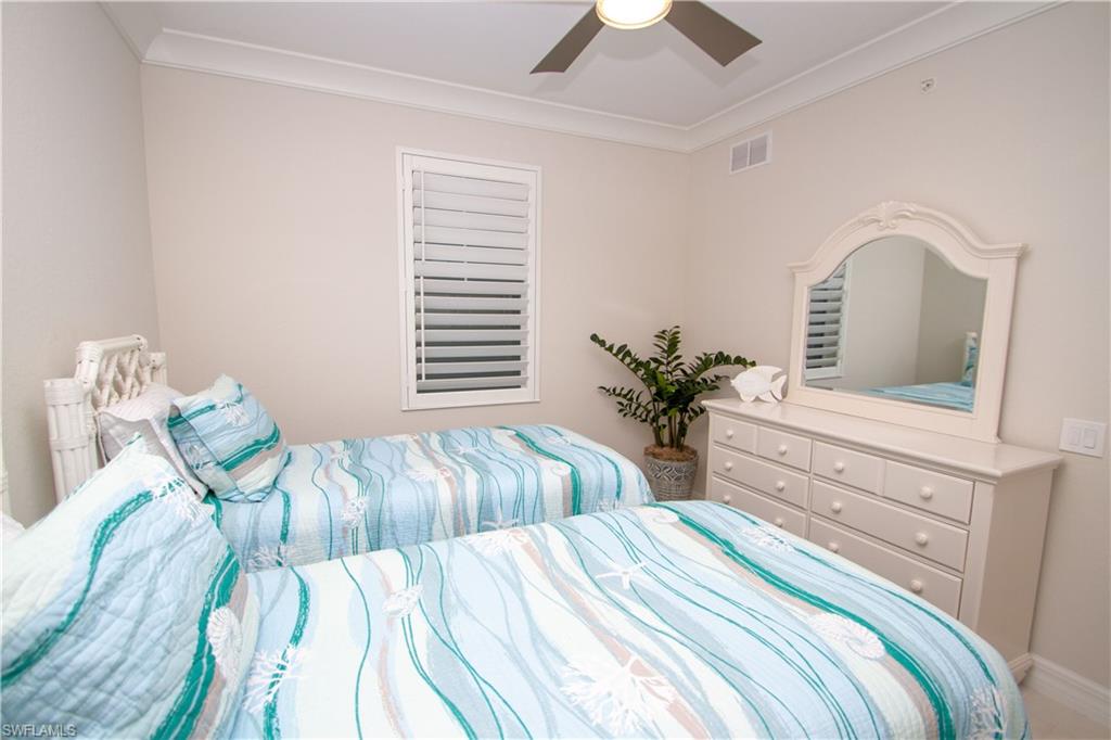 232 Indies Drive East, Unit 101 Naples, FL 34114 - Photo 17 of 50 a bedroom with two beds and a potted plant