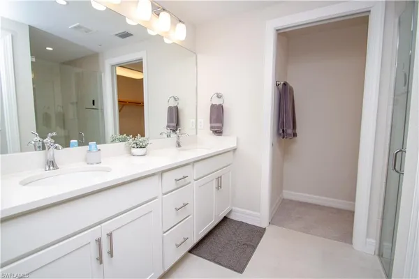 a bathroom with a double vanity sink and a mirror