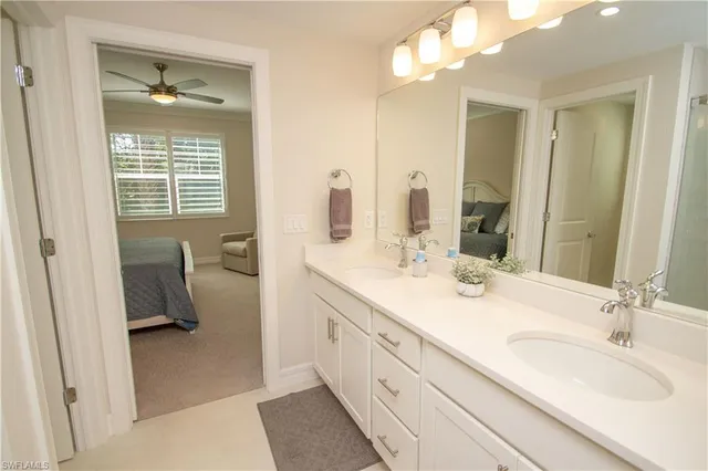 a en suite bathroom with a double vanity sink a mirror and a shower
