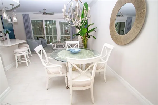 a dining room with furniture potted plants and wooden floor