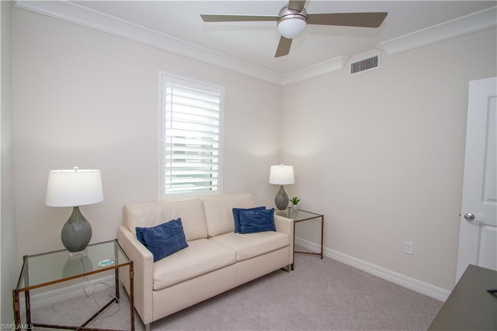 232 Indies Drive East, Unit 101 Naples, FL 34114 - Photo 31 of 50 a living room with furniture and a lamp