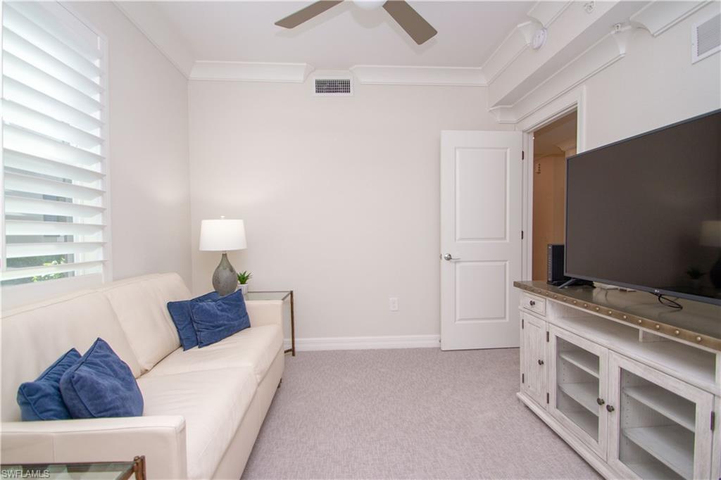 232 Indies Drive East, Unit 101 Naples, FL 34114 - Photo 32 of 50 a living room with furniture and a flat screen tv