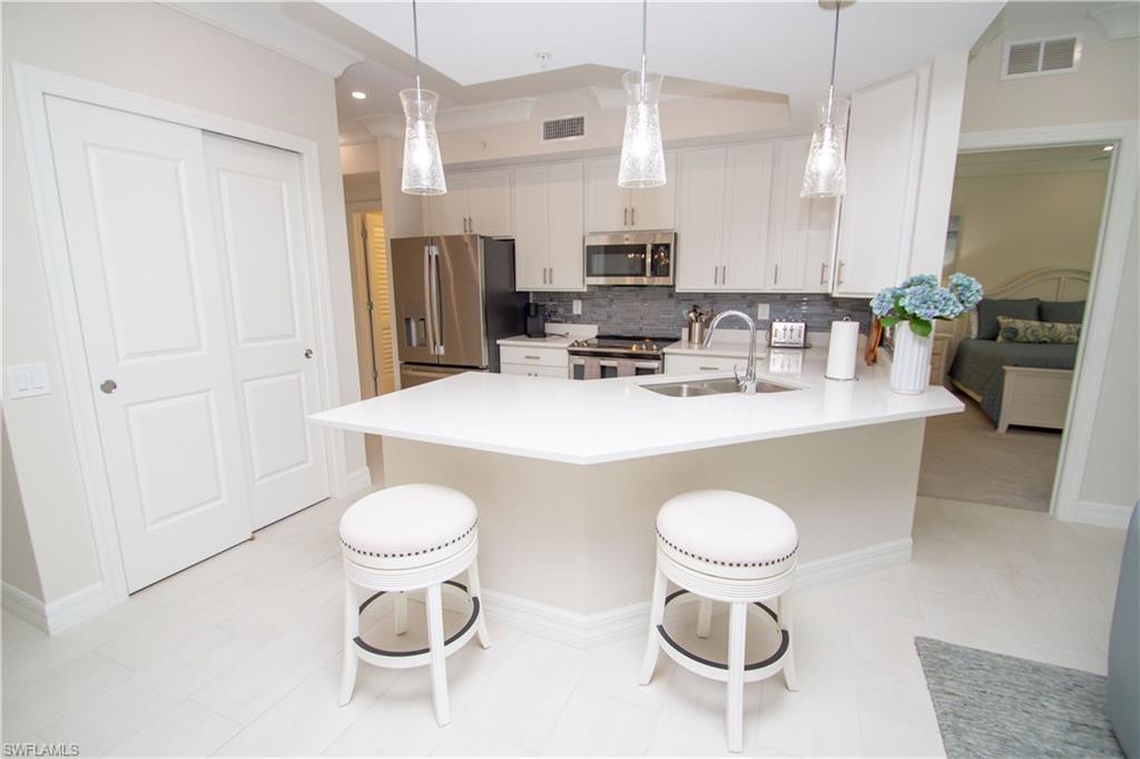 232 Indies Drive East, Unit 101 Naples, FL 34114 - Photo 8 of 50 a kitchen with a table and chairs