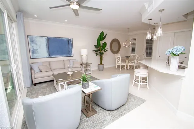 a living room with furniture a chandelier and a table