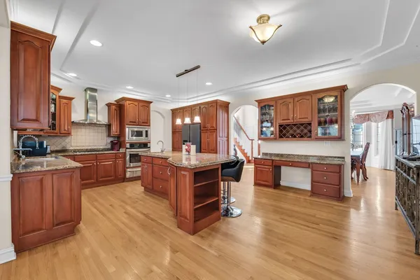 a kitchen with stainless steel appliances wooden floors stove and kitchen island