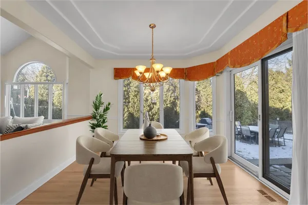 a dining room with furniture a chandelier and wooden floor