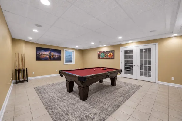 a room with pool table and windows