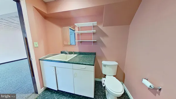 a bathroom with a granite countertop toilet and a sink