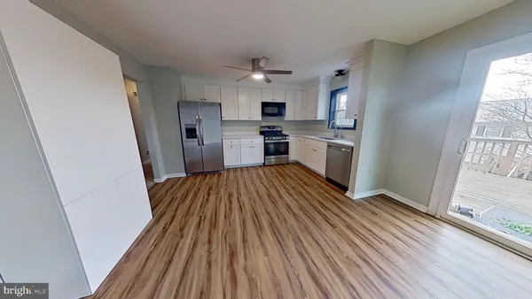 a view of a kitchen with wooden floor and stainless steel appliances