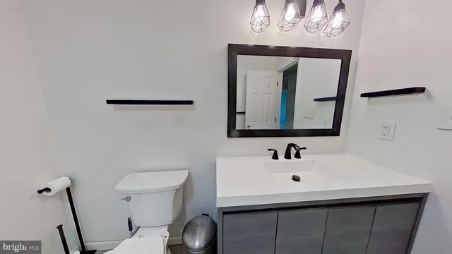 a bathroom with a toilet sink and mirror
