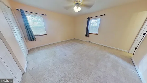 an empty room with windows and closet