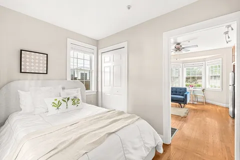 a bedroom with a bed and wooden floor