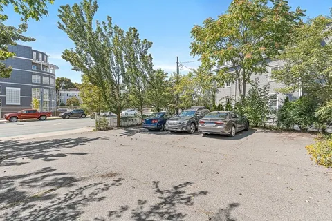 a view of road with card parked on side and road