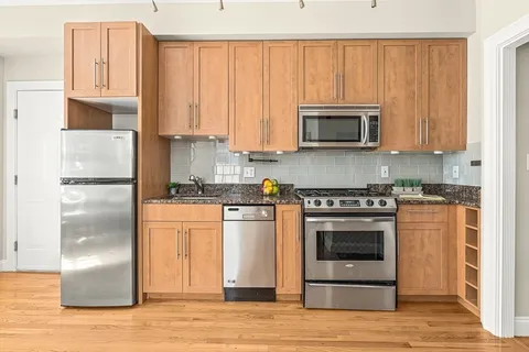a kitchen with granite countertop a refrigerator stove and microwave