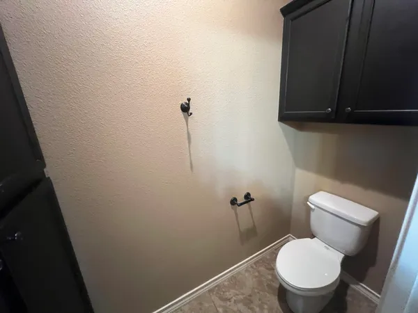 a white toilet sitting in a bathroom next to a sink