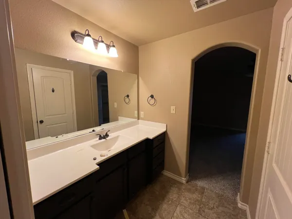 a room with a sink vanity and a mirror