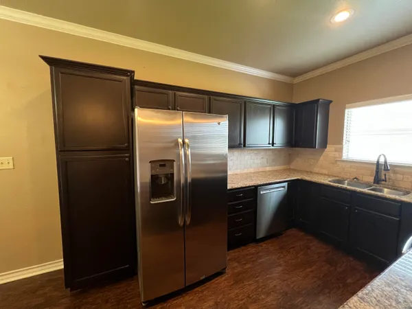 a kitchen with stainless steel appliances granite countertop a refrigerator and a sink
