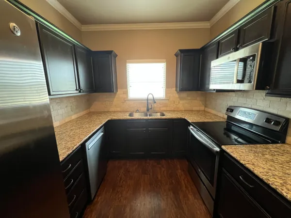 a kitchen with a sink stove top oven and microwave
