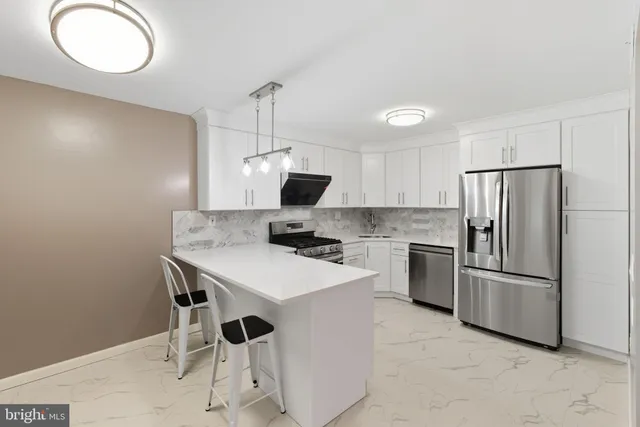 a kitchen with white cabinets and stainless steel appliances
