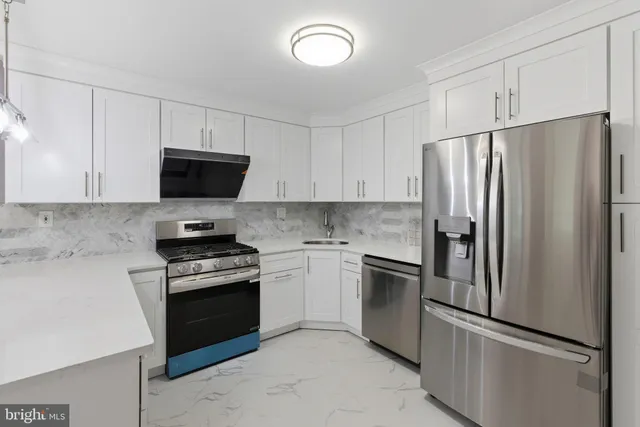 a kitchen with white cabinets and stainless steel appliances