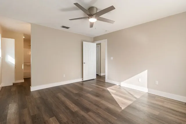 a view of a big room with wooden floor and a ceiling fan
