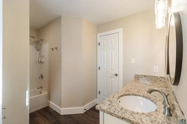 a bathroom with a granite countertop sink and a mirror