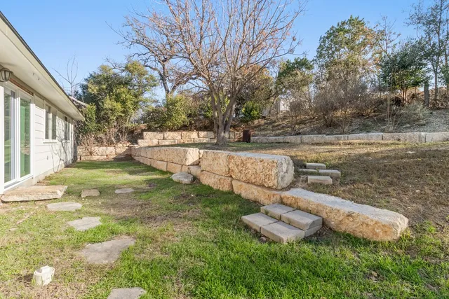a view of a backyard with plants and a lake view