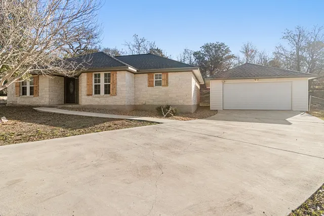a view of a grey house with a yard