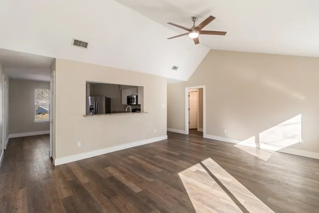 a view of a livingroom with wooden floor and a ceiling fan