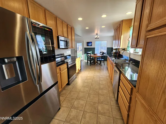 a kitchen with granite countertop a stove a microwave a sink and cabinets