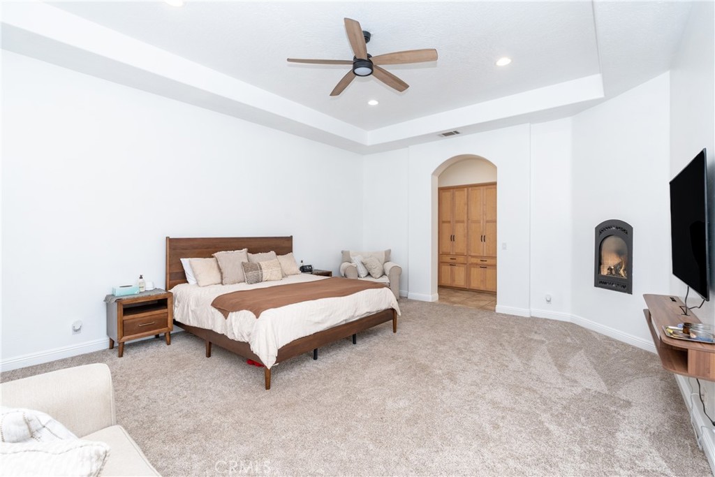 1830 Calaveras Road Pinon Hills, CA 92372 - Photo 13 of 38 a spacious bedroom with a bed and a ceiling fan
