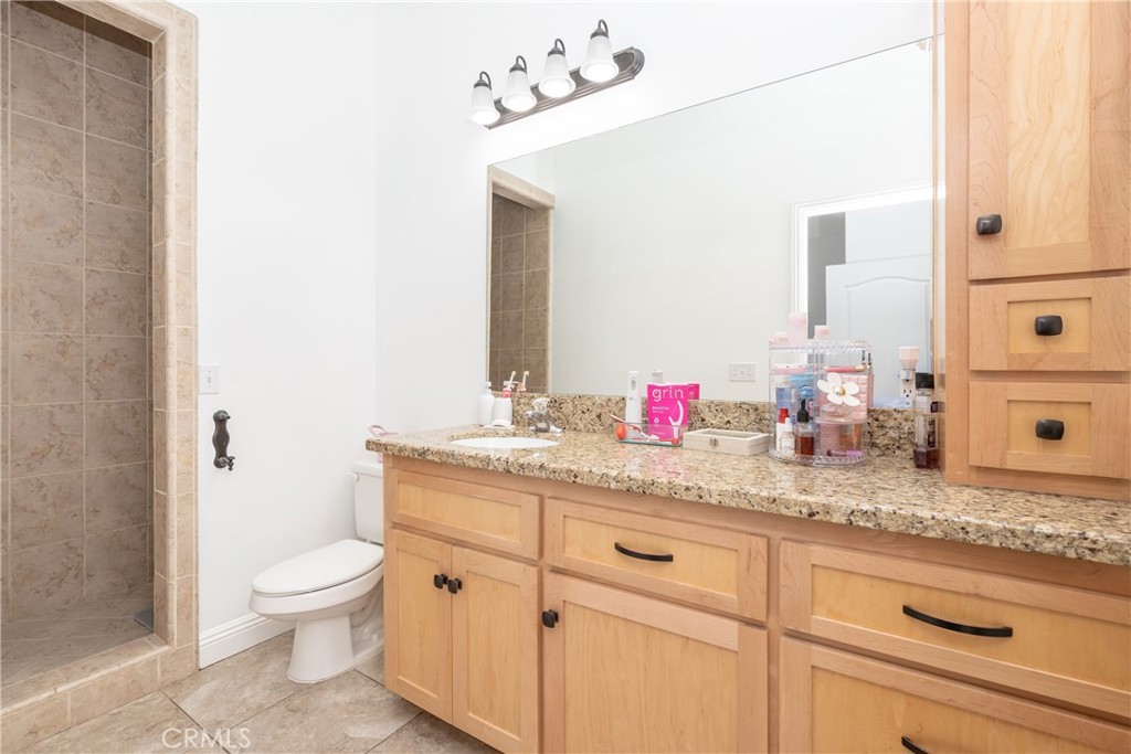 1830 Calaveras Road Pinon Hills, CA 92372 - Photo 24 of 38 a bathroom with a granite countertop sink a toilet and a mirror