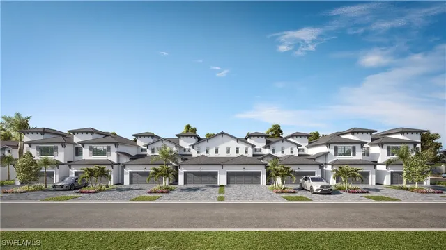 a front view of a building with lots of trees and plants