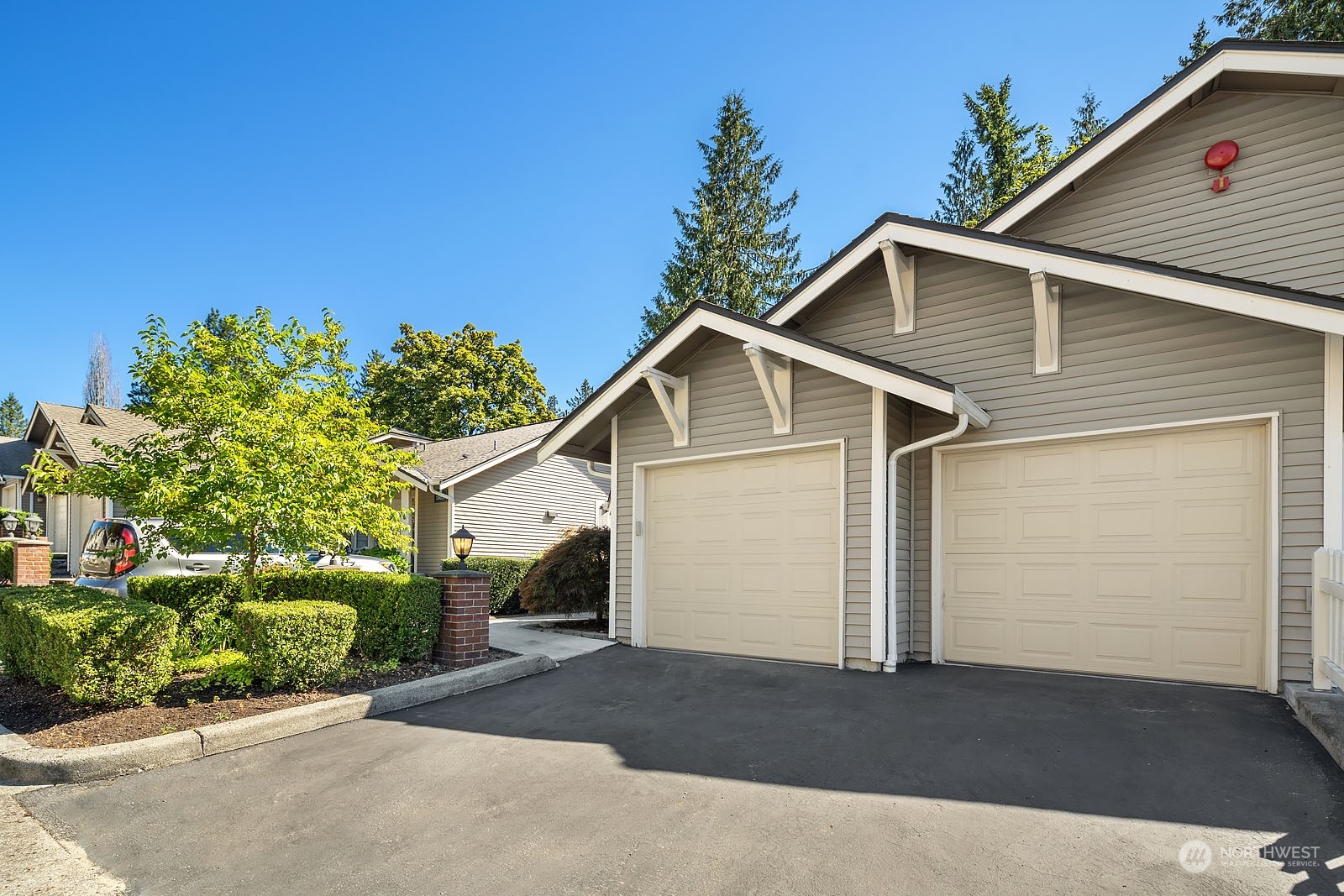 18651 Northeast 55th Way, Unit PP Redmond, WA 98052 - Photo 29 of 35 a view of a white house with a yard and garage