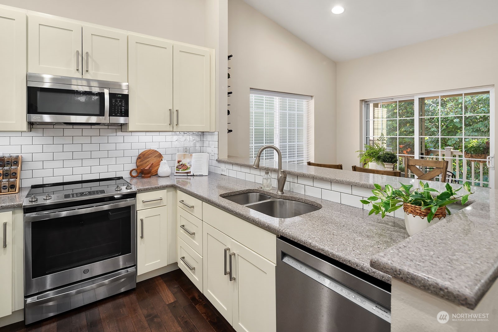 18651 Northeast 55th Way, Unit PP Redmond, WA 98052 - Photo 9 of 35 a kitchen with stainless steel appliances granite countertop a sink a stove a microwave and wooden cabinets