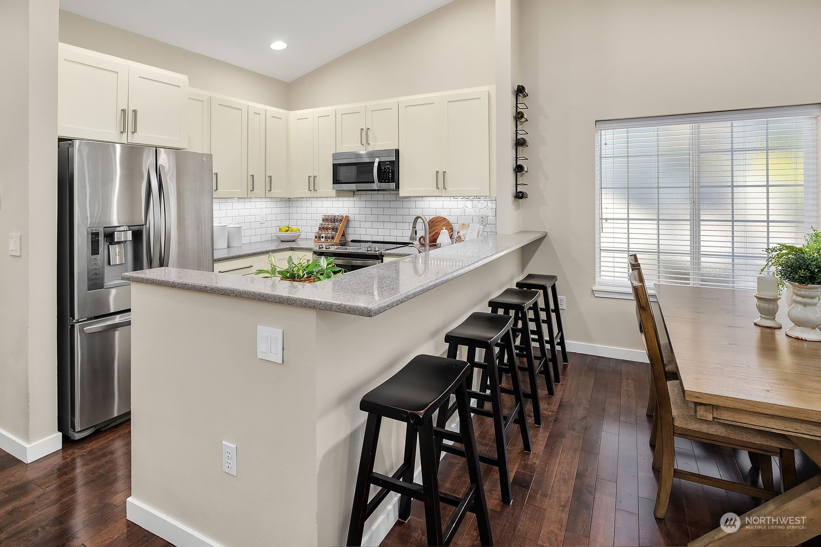 18651 Northeast 55th Way, Unit PP Redmond, WA 98052 - Photo 10 of 35 a kitchen with stainless steel appliances a dining table chairs refrigerator and microwave