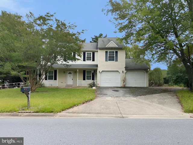 a front view of a house with a garden and yard