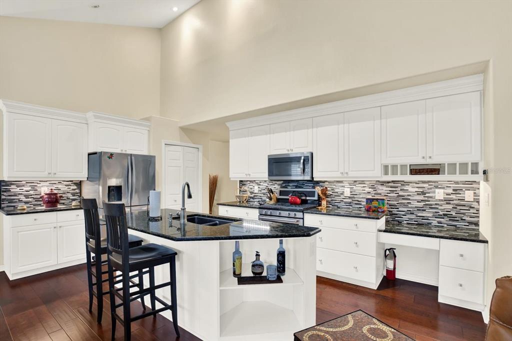 2021 Meadow Rue Court Trinity, FL 34655 - Photo 9 of 41 a kitchen with stainless steel appliances kitchen island granite countertop a stove a sink dishwasher and a refrigerator