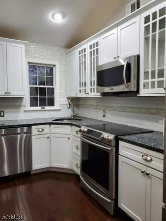 a kitchen with stainless steel appliances granite countertop a stove microwave and sink