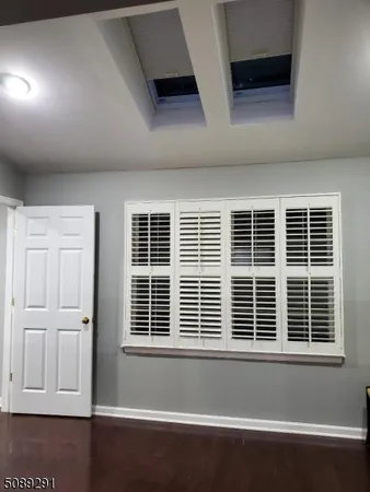 a view of empty room with wooden floor and windows