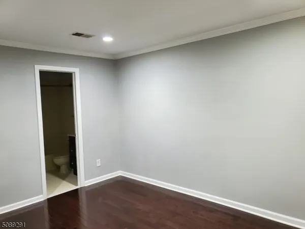 an empty room with wooden floor and closet