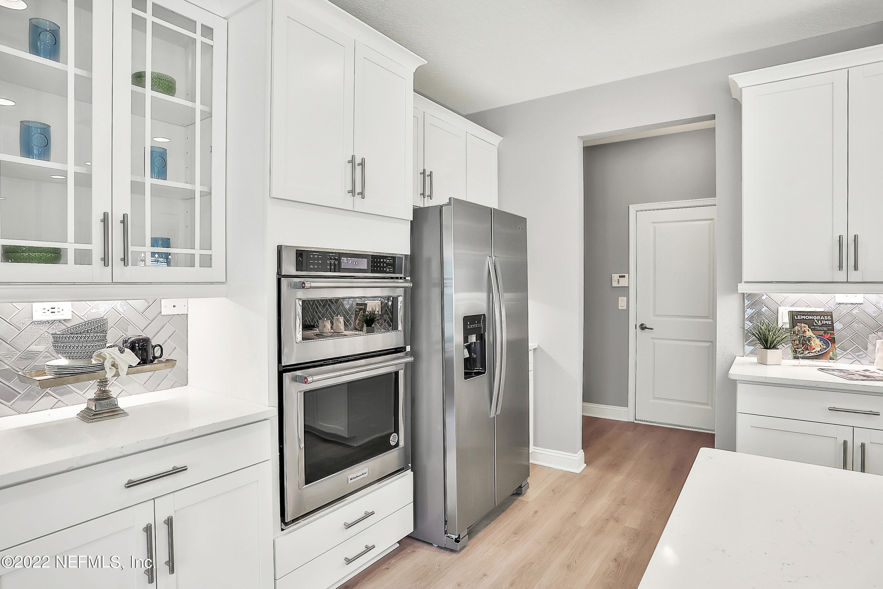 117 Crew Court St. Augustine, FL 32092 - Photo 22 of 64 a kitchen with stainless steel appliances white cabinets and wooden floor