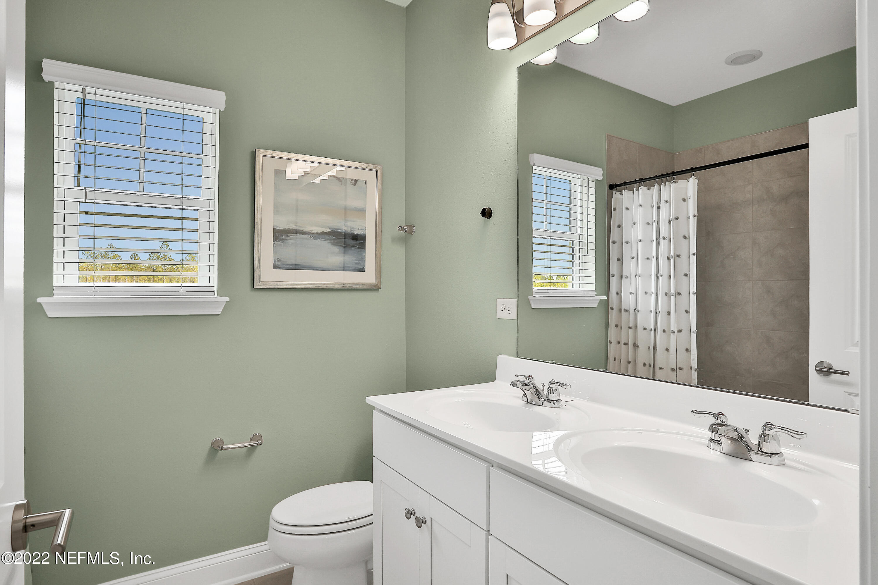 117 Crew Court St. Augustine, FL 32092 - Photo 31 of 64 a bathroom with a granite countertop sink a toilet and a large mirror