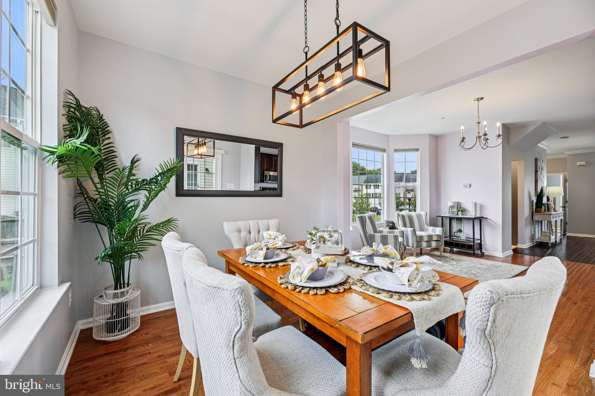 690 Tivoli Road Frederick, MD 21703 - Photo 14 of 43 a dining room with furniture potted plants and wooden floor