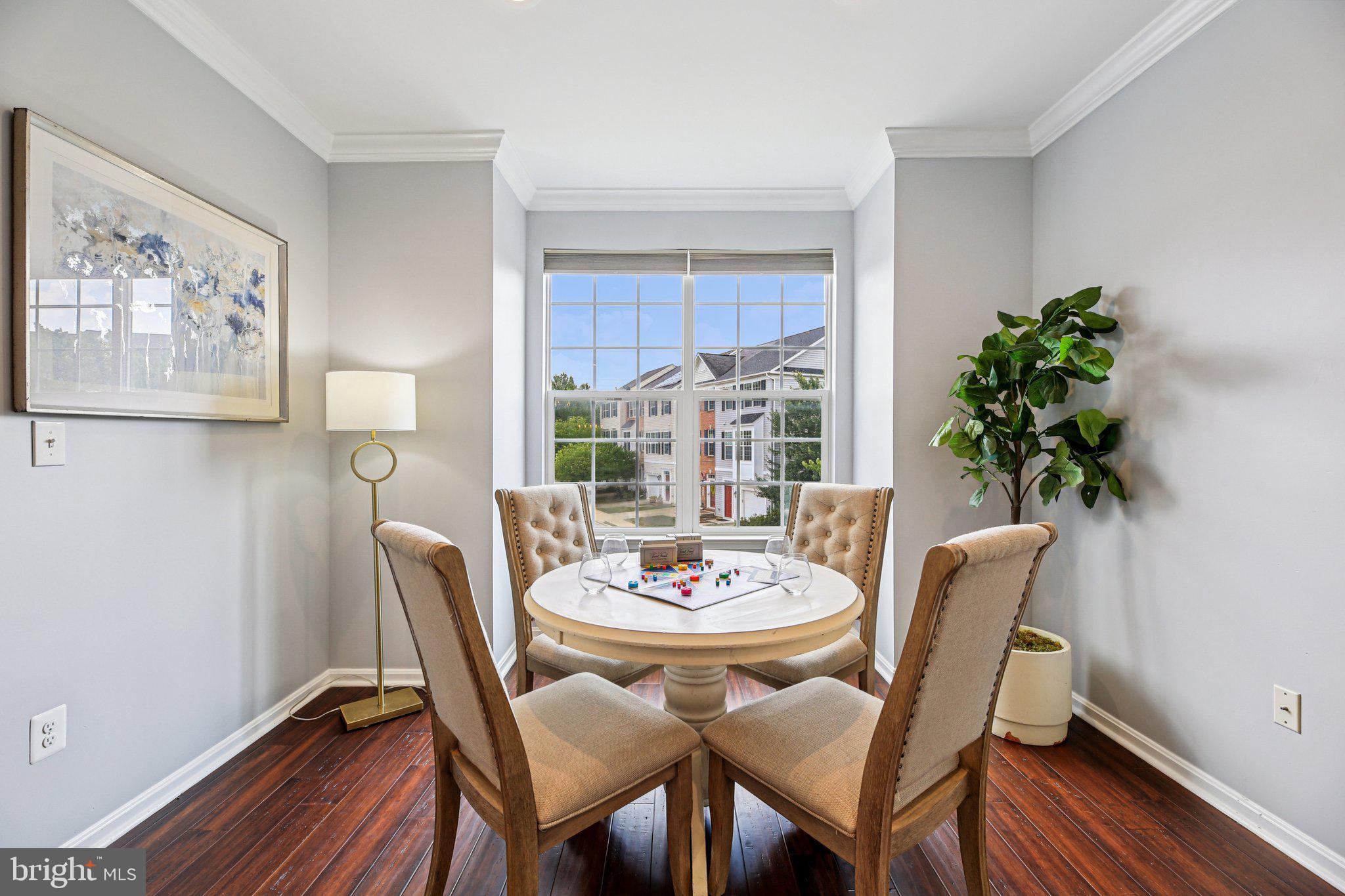 690 Tivoli Road Frederick, MD 21703 - Photo 6 of 43 a dining room with furniture potted plants and wooden floor