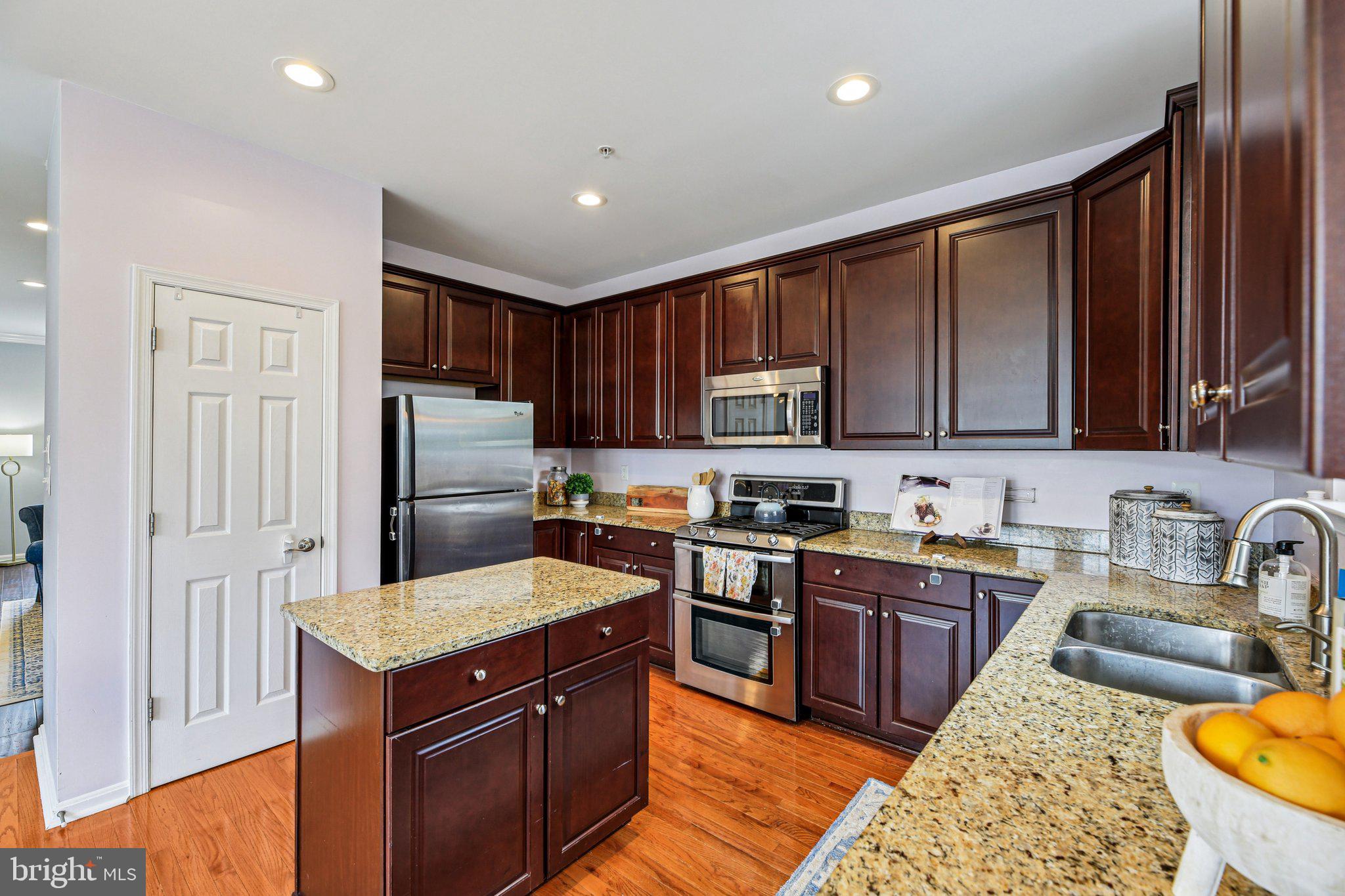 690 Tivoli Road Frederick, MD 21703 - Photo 10 of 43 a kitchen with stainless steel appliances granite countertop a stove a sink dishwasher a refrigerator and a microwave oven with wooden floor