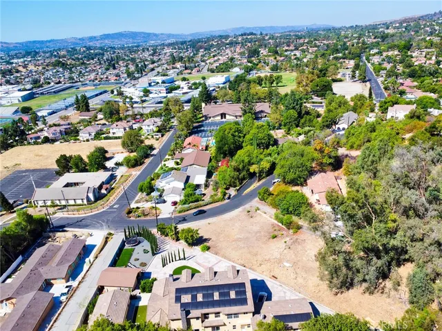 an aerial view of residential houses with outdoor space and street view