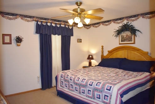 25109 Indian Ridge Road Sterling, IL 61081 - Photo 24 of 34 a bedroom with a bed a chandelier and a window