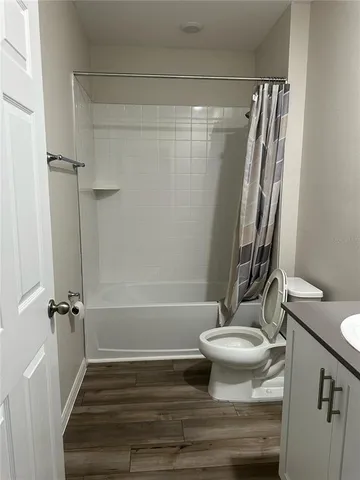 a bathroom with a sink a toilet a mirror and shower